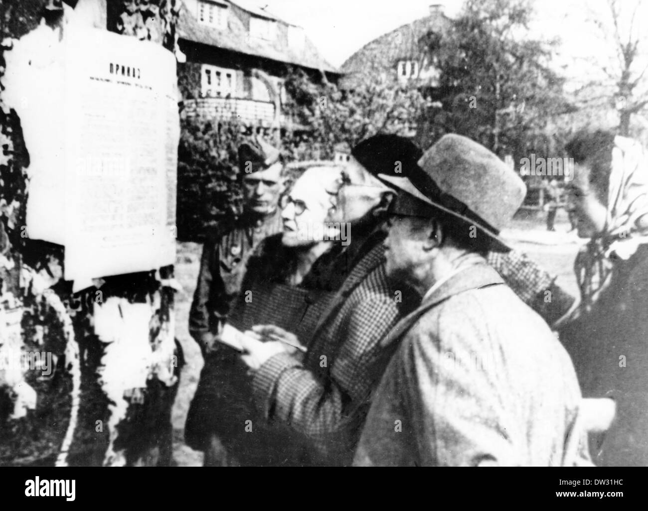 Nach dem Ende des Krieges in Berlin im Jahr 1945 las man einen der ersten Befehle des sowjetischen Militärkommandos vor einem Soldaten der Roten Armee in einem Vorort von Berlin. Fotoarchiv für Zeitgeschichte - KEIN KABELDIENST Stockfoto