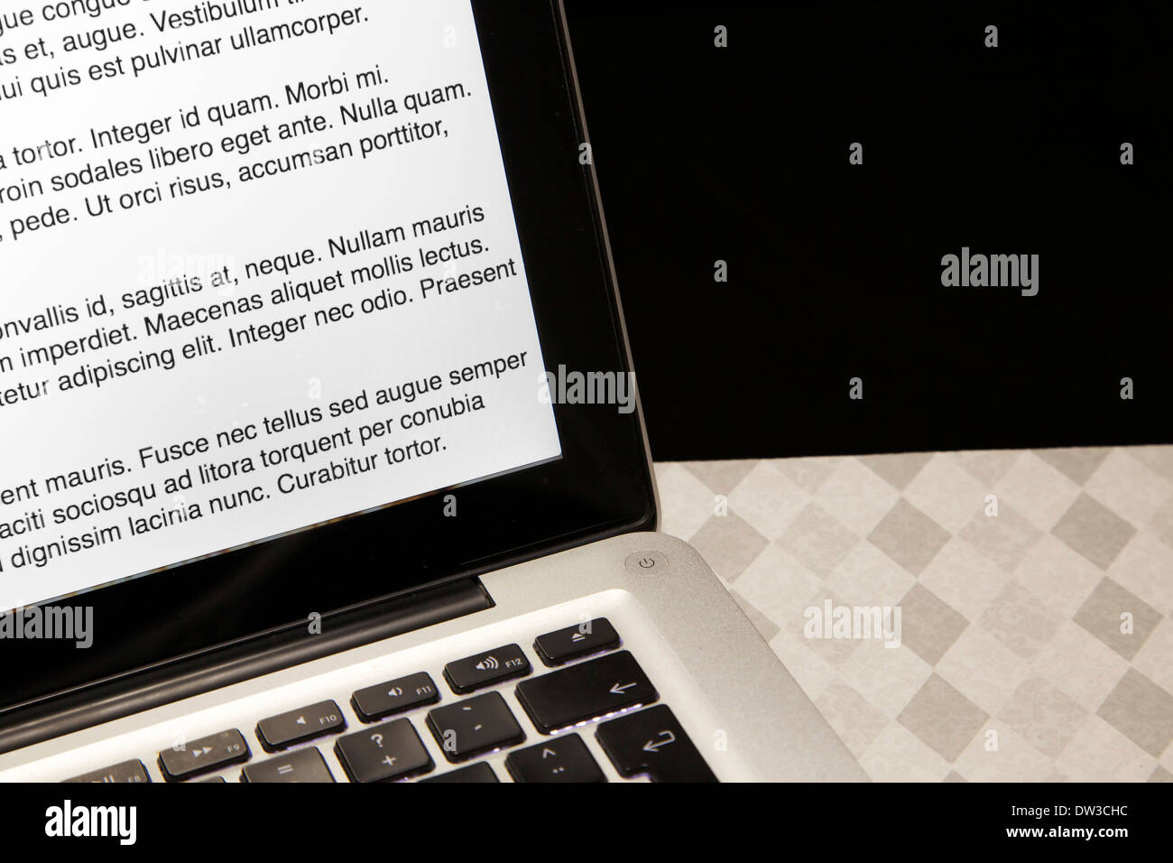Laptop auf einer karierten Fläche mit schwarzem Hintergrund Stockfoto