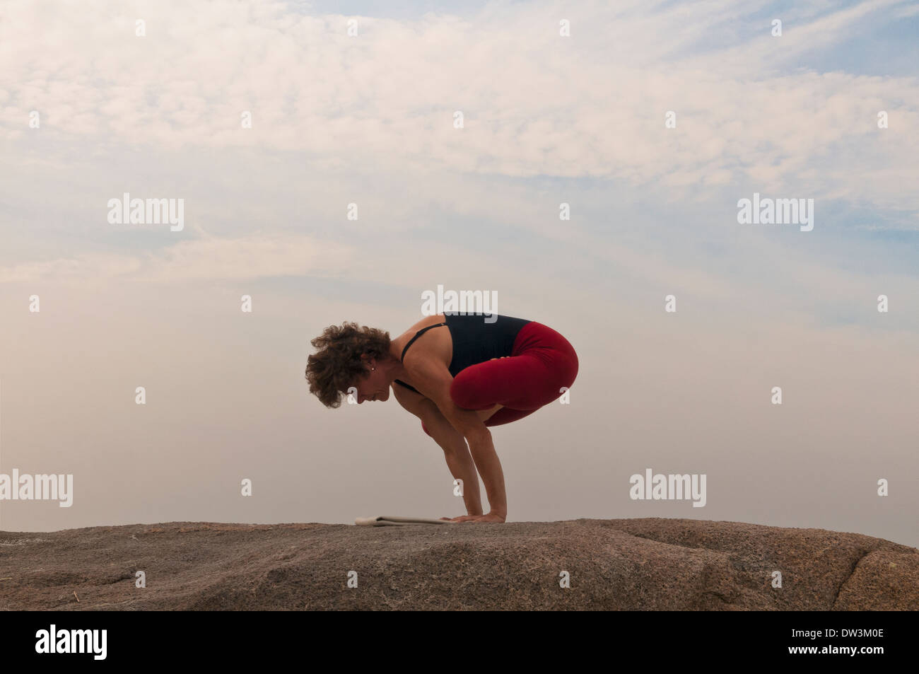 Iyengar Yoga-Lehrer zeigt Kukkutasana (Ausgleich). Stockfoto