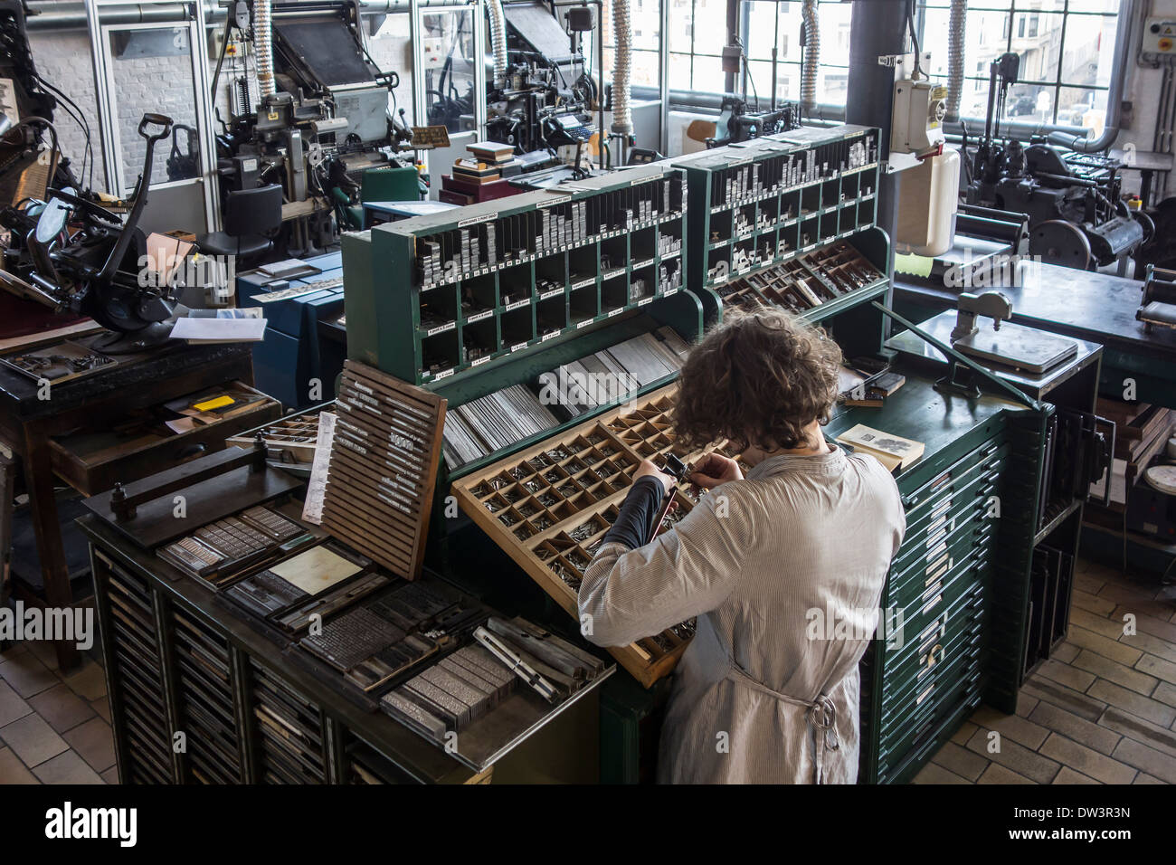 Schriftsetzer bei der Arbeit in die Setzerei im Druckgeschäft bei MIAT, industrielle Archäologiemuseum, Gent, Belgien Stockfoto