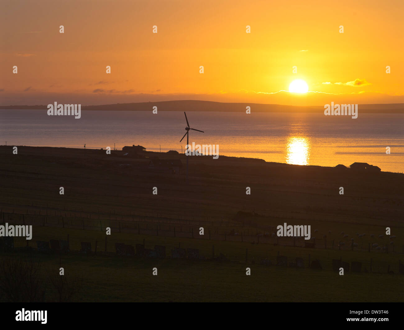 dh Scapa Flow ORPHIR ORKNEY Sunrise Windkraftanlagen Ferienhäuser Meer großbritannien schottland Dämmerung Haus Sonne Aufgang über Feld Stockfoto