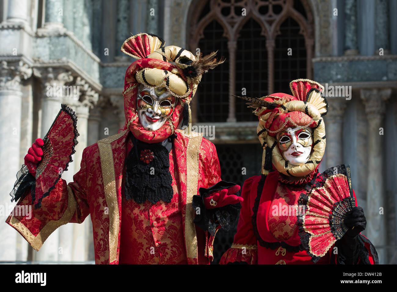 Venedig, Italien. 26. Februar 2014. Andrea Boni und Partner stellen anmutig in ihren Masken und roten Kostümen vor der Basilika San Marco (Markusplatz Basilika) während dem Karneval von Venedig - Mittwoch, 26. Februar. Bildnachweis: MeonStock/Alamy Live-Nachrichten Stockfoto