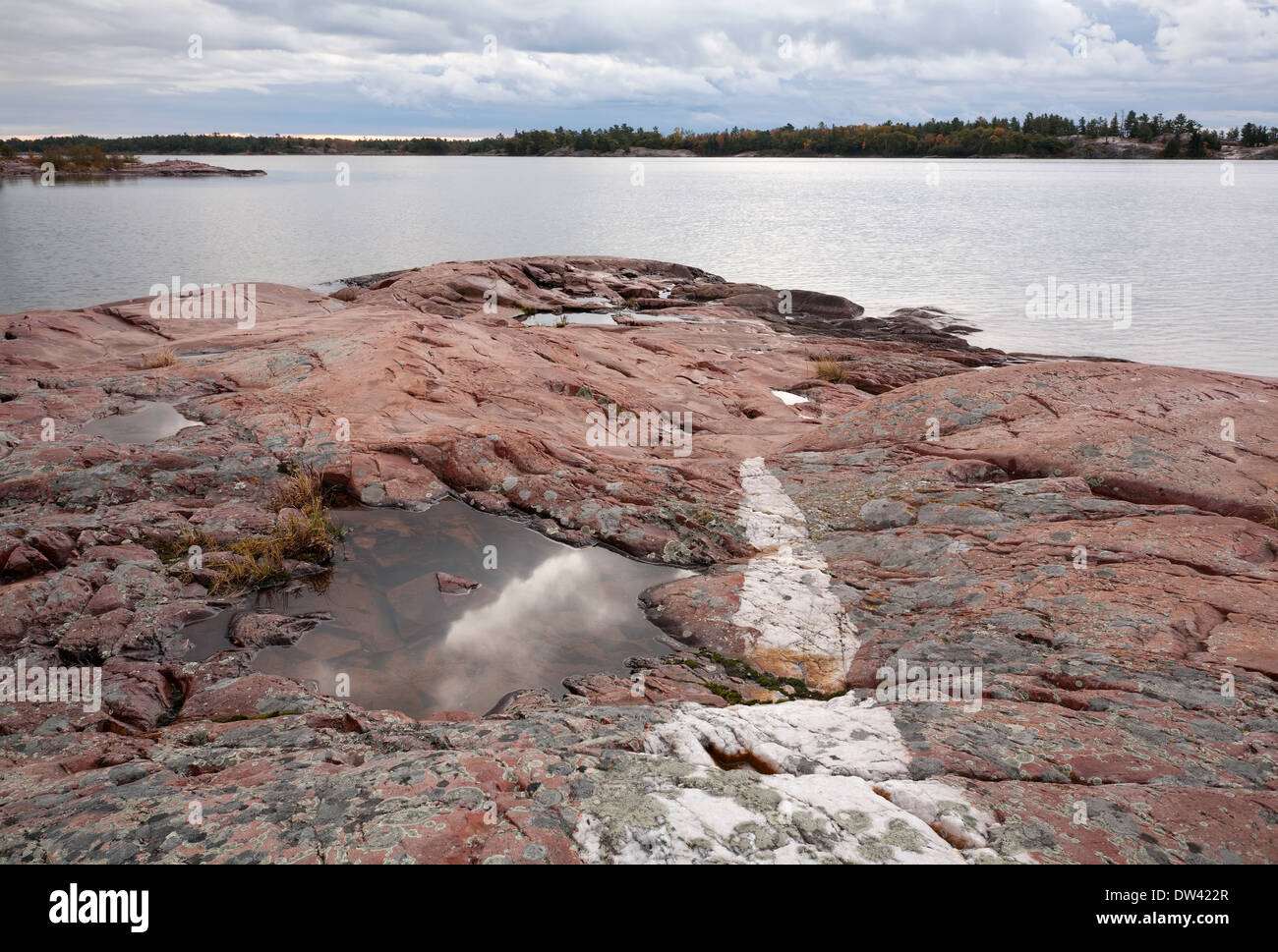 Ein Streifen weiß Quarzit teilt roter Granit am Ufer des Killarney Provincial Park in Ontario, Kanada. Stockfoto