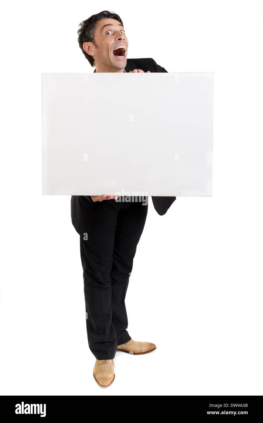 Geschäftsmann hält eine leere weiße Karte oder Zeichen vor der Brust mit einer übertriebenen mit offenem Mund Aussehen des Staunens Stockfoto