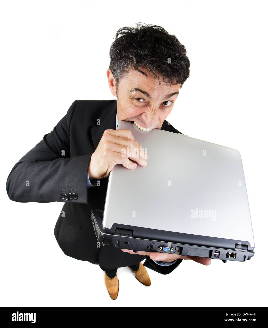 Humorvolle hohen Winkel in voller Länge Portrait frustriert Geschäftsmann beißen seine Laptop-Computer in ihrer Verzweiflung isoliert auf weiss Stockfoto
