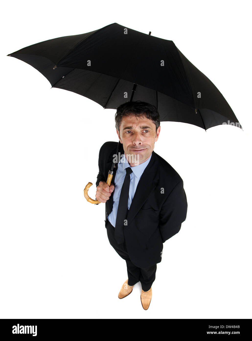 Hohen Winkel voller Länge Porträt eines attraktiven dapper Kaufmanns bergende unter einem großen schwarzen Schirm nachschlagen Stockfoto