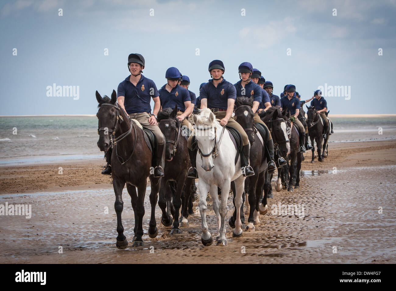 Reiter und Frauen die Blues and Royals trainieren ihre Pferde in der Brandung am Holkham Beach Norfolk, Großbritannien Stockfoto