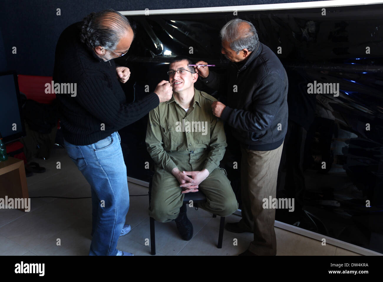 Gaza, Palästinensische Gebiete. 27. Februar 2014. Schauspieler Mahmoud Karira, der Gilad Schalit spielt, hat Make-up angewendet von einem Assistenten während der Dreharbeiten eines Films im Gaza-Streifen namens "Verlieren Shalit" gemacht. "Schalit verliert", derzeit in dem abgeriegelten Gebiet gefilmt wird, ist der erste einer geplanten dreiteiligen Serie über die 2006 Aufnahme des israelischen Soldaten Gilad Schalit von bewaffneten verbündete sich mit den islamischen Militanten Hamas-Bewegung. Teile zwei und drei werden Schalits Zeit in Gefangenschaft und seine 2011 Swap für Hunderte von palästinensischen Häftlinge durch Israel darzustellen. (Kredit-Bild: © Majdi Fathi/NurPhoto/ZUM Stockfoto