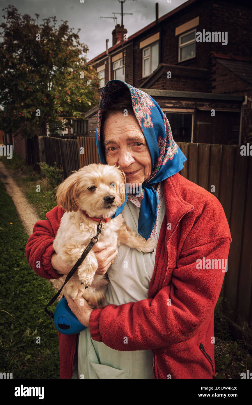 Alte Dame heraus für einen Spaziergang mit ihrem Hund posiert für die Kamera Stockfoto