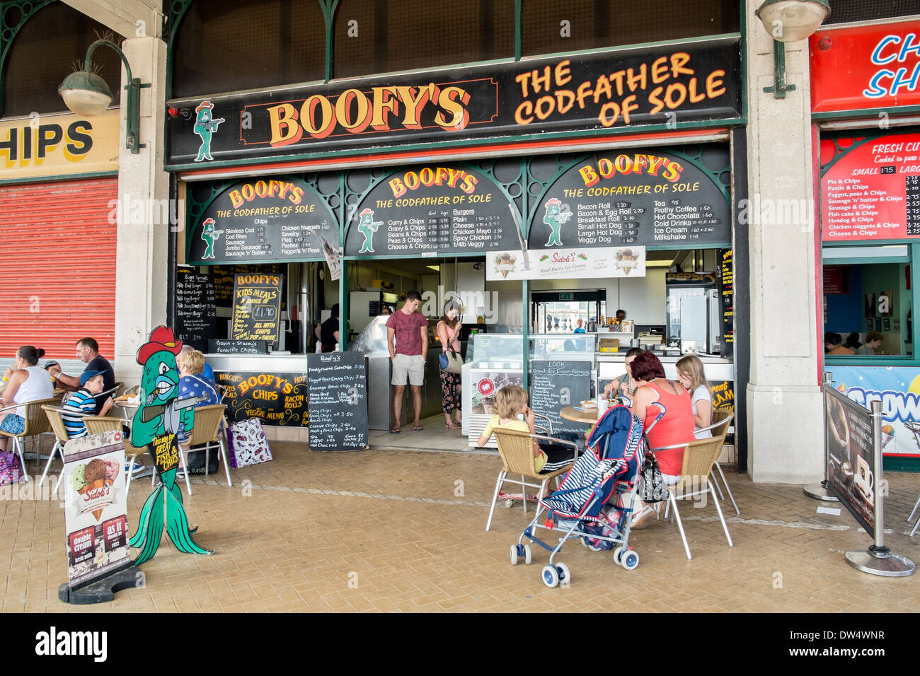 Touristen, Tagestouristen & Einheimischen genießen frischen Fisch & Chips im Boofy Shop an der Strandpromenade in Barry, South Wales Stockfoto