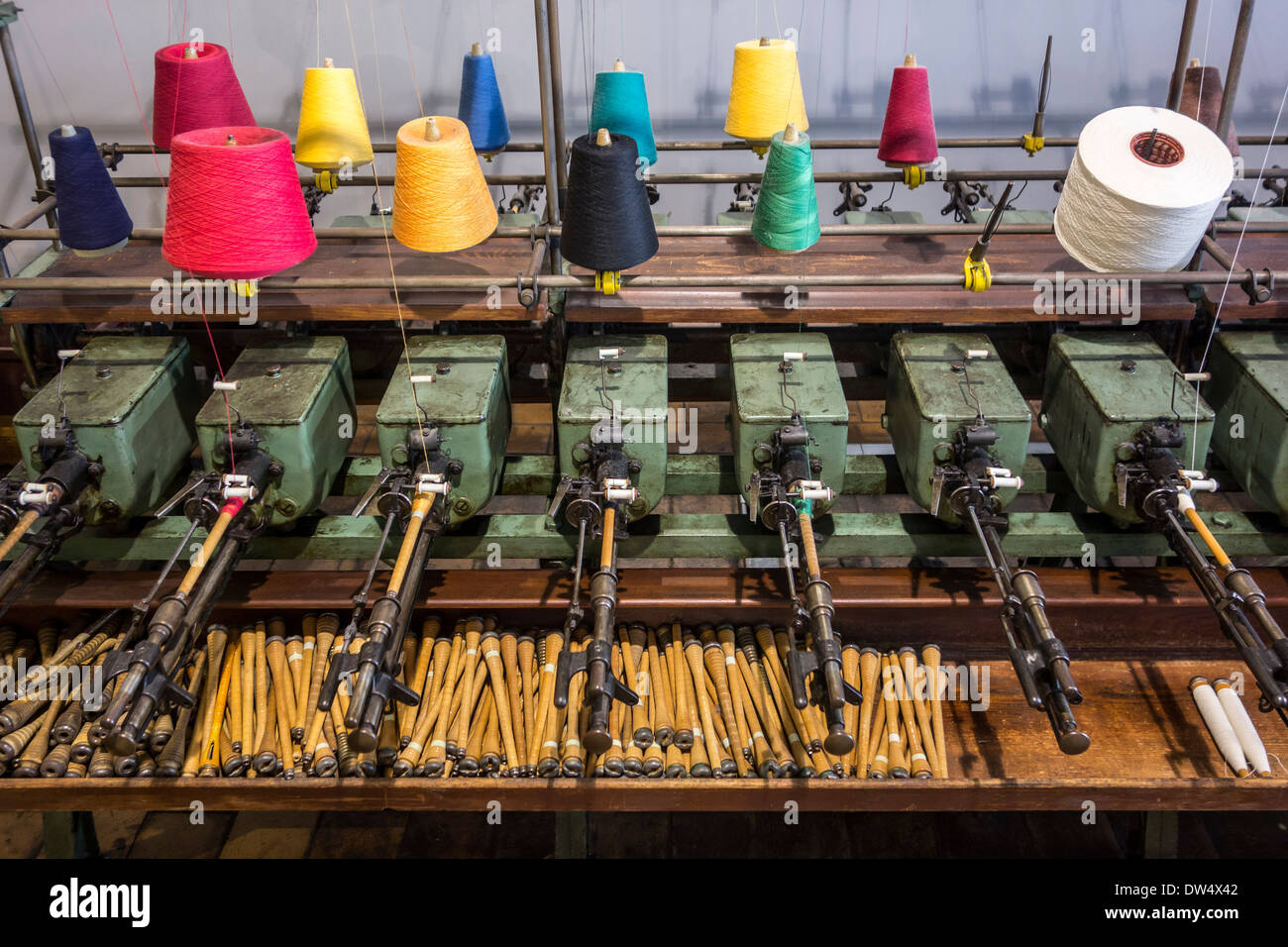 Bunte Spulen mit Garn auf der Spule Maschine in Baumwollspinnerei bei MIAT, industrielle Archäologiemuseum, Gent, Belgien Stockfoto