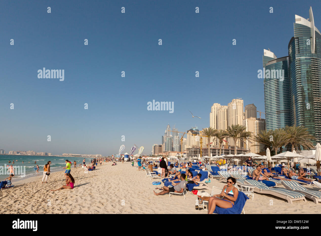 Touristen, Sonnenbaden am Strand von Jumeirah im Februar, Dubai, Vereinigte Arabische Emirate, naher Vereinigte Arabische Emirate, Osten Stockfoto