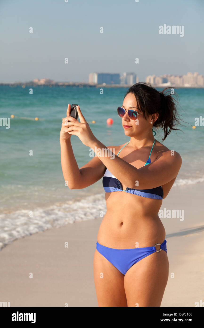 Junge Frau im Bikini fotografieren Selfie von sich selbst am Jumeirah Beach, Dubai Vereinigte Arabische Emirate VAE Naher Osten Stockfoto