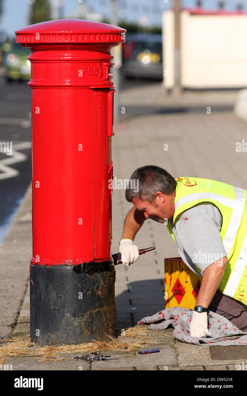 Ein Arbeiter malt eine Königliche Post-Steckbox Stockfoto