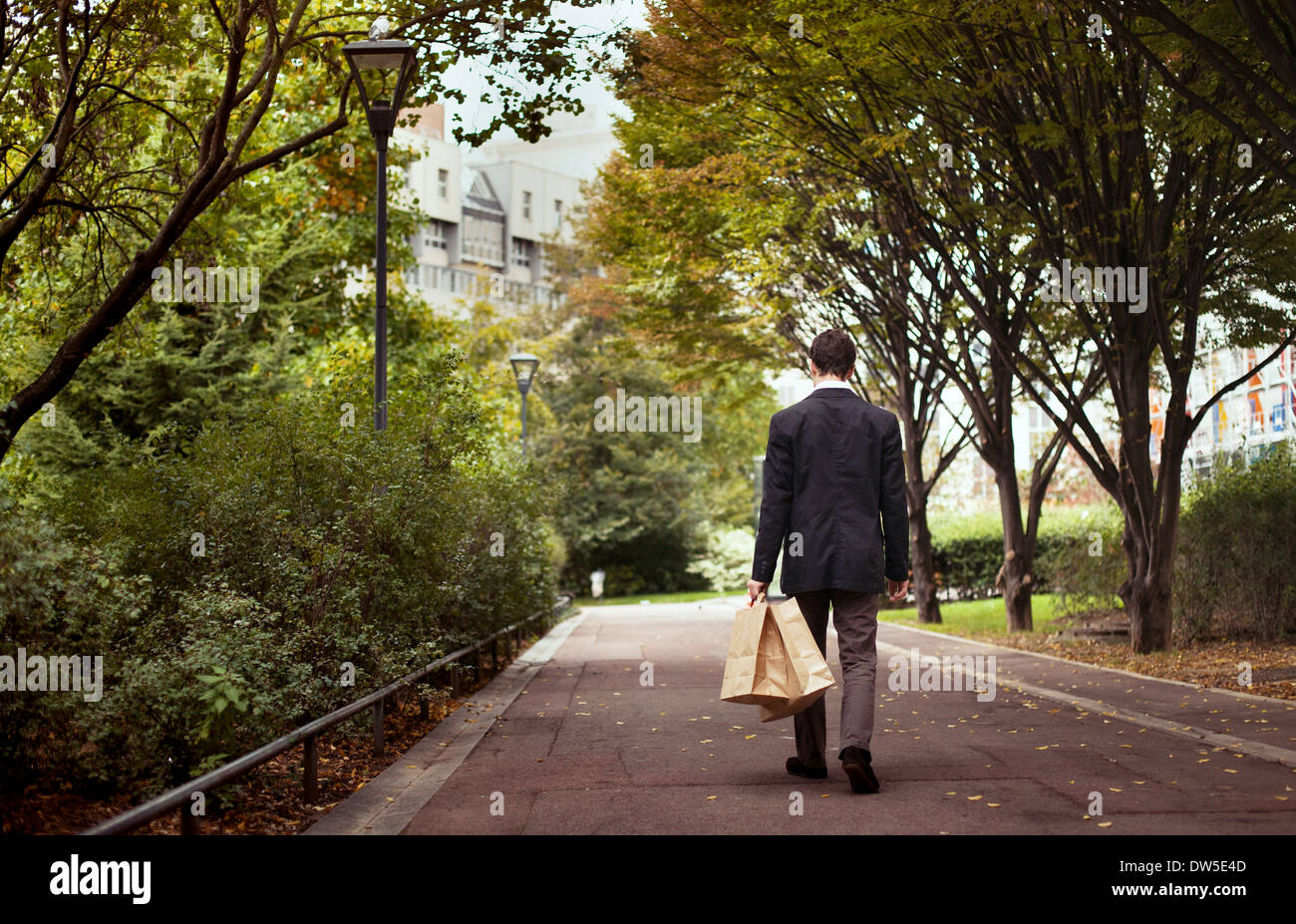 Einsamkeit, einsamer Mann mit Einkaufstüten Spaziergang nach der Arbeit Stockfoto