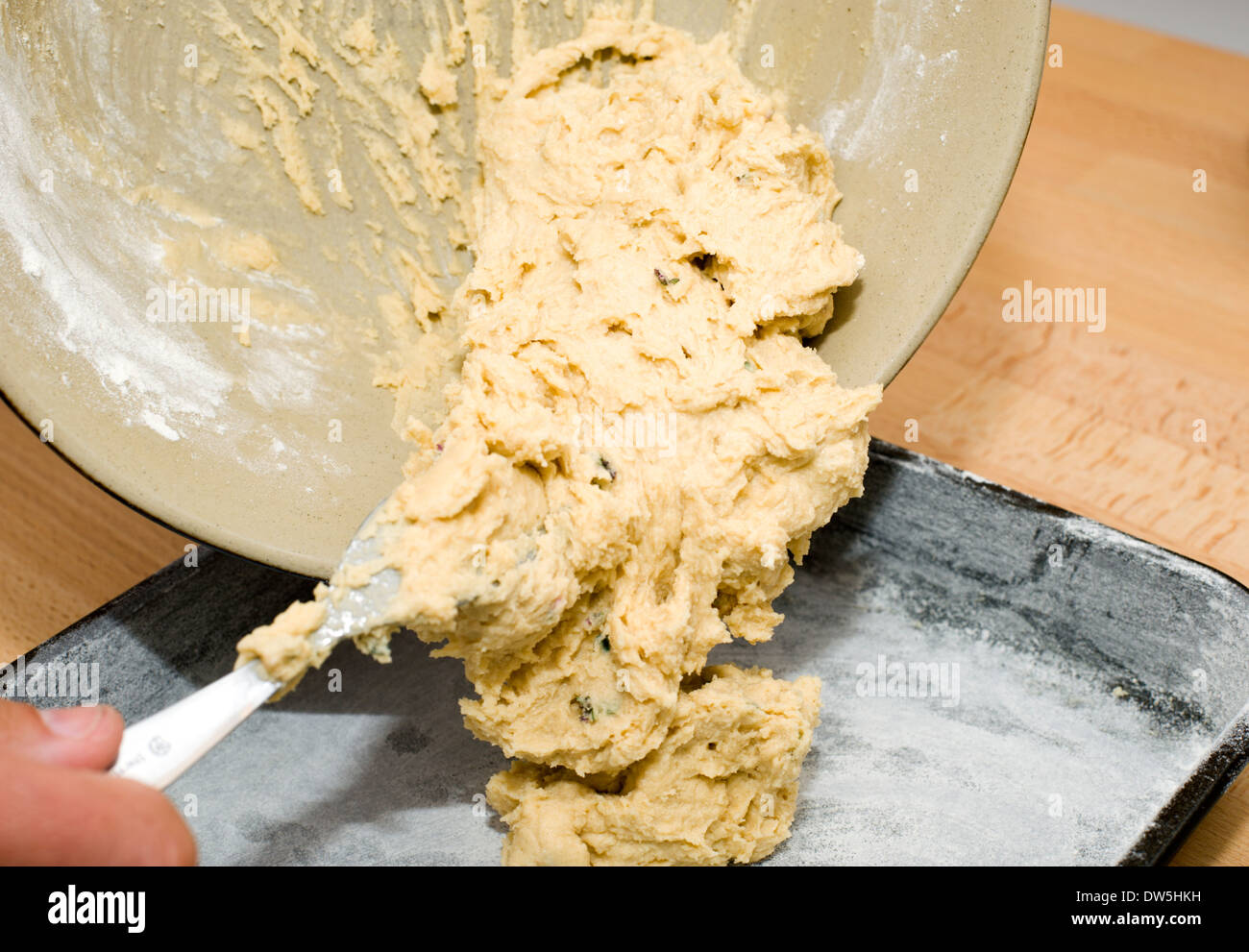 Löffelt eine hausgemachte Kuchen Mischung in einer bemehlten Backblech fertig zum Backen im Ofen Stockfoto