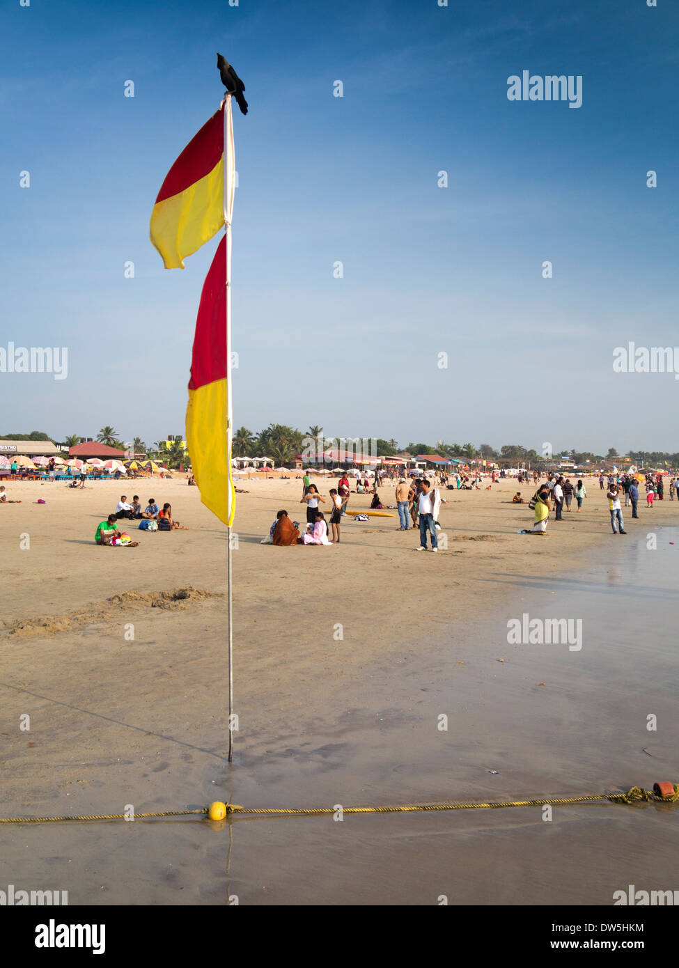 Indien, Goa, Baga, indische Touristen am Strand Rettungsschwimmer zwischen sicheren Baden Fahnen Stockfoto