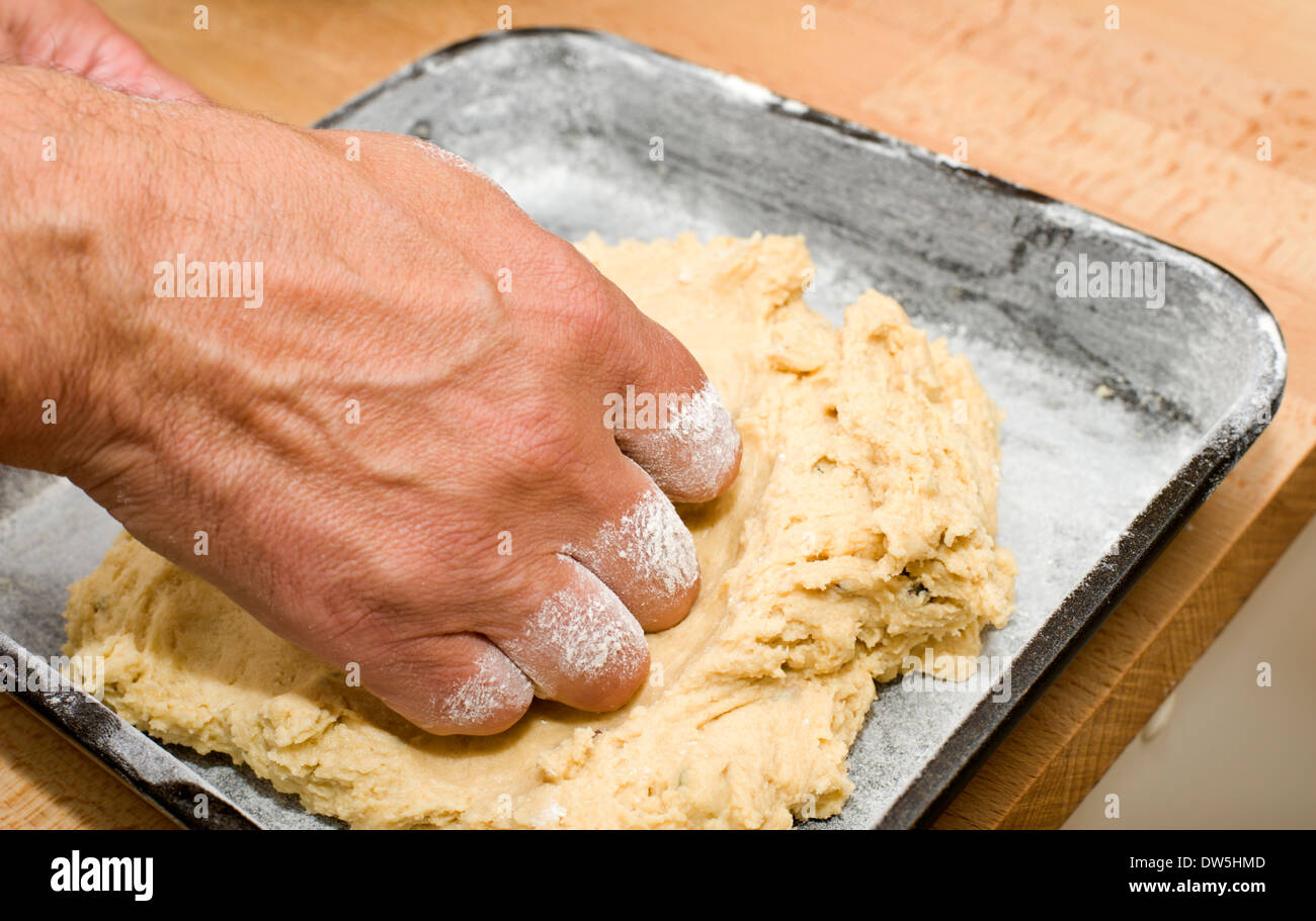 Drücken Sie hausgemachten Kuchen Mischung in einem bemehlten Backblech fertig zum Backen im Ofen Stockfoto