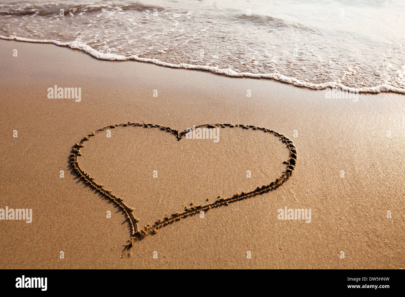 Herz am Sandstrand, Valentinstag Hintergrund gezeichnet Stockfoto