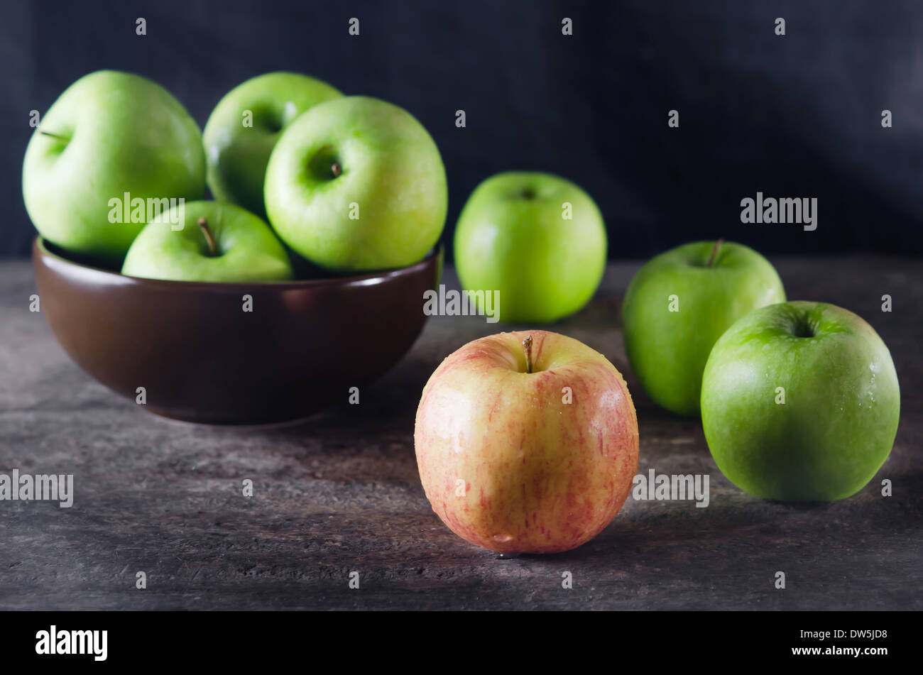 Schüssel mit grünem Apfel und Apfel über Holzbrett Stockfoto