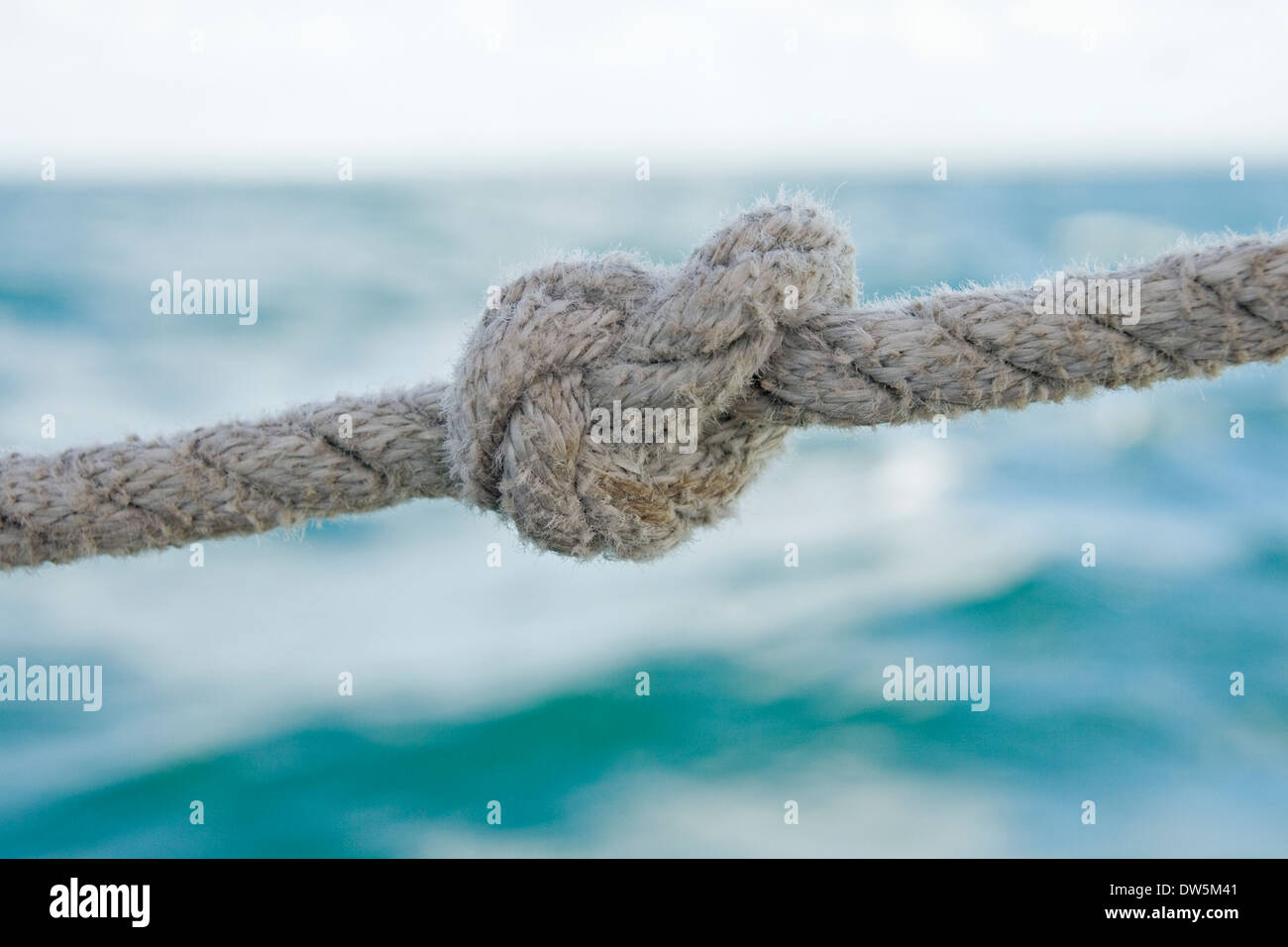 Knoten Sie an einem Seil gegen Meerwasser Stockfoto