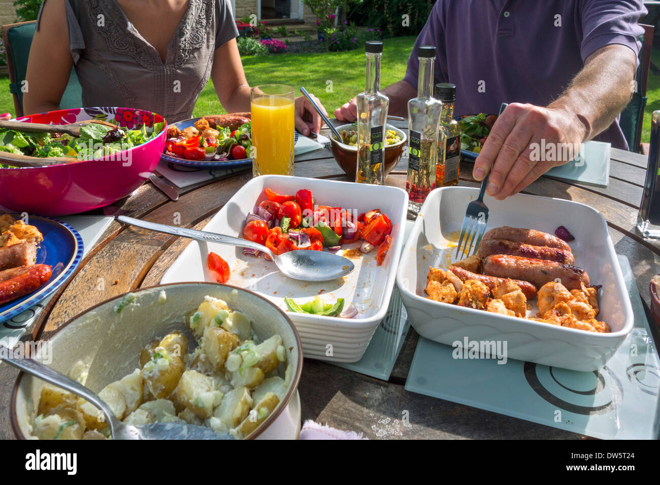 Grillen im Sommer an einem Tisch in einem englischen Landhaus Garten, West Yorkshire, England, UK, Stockfoto