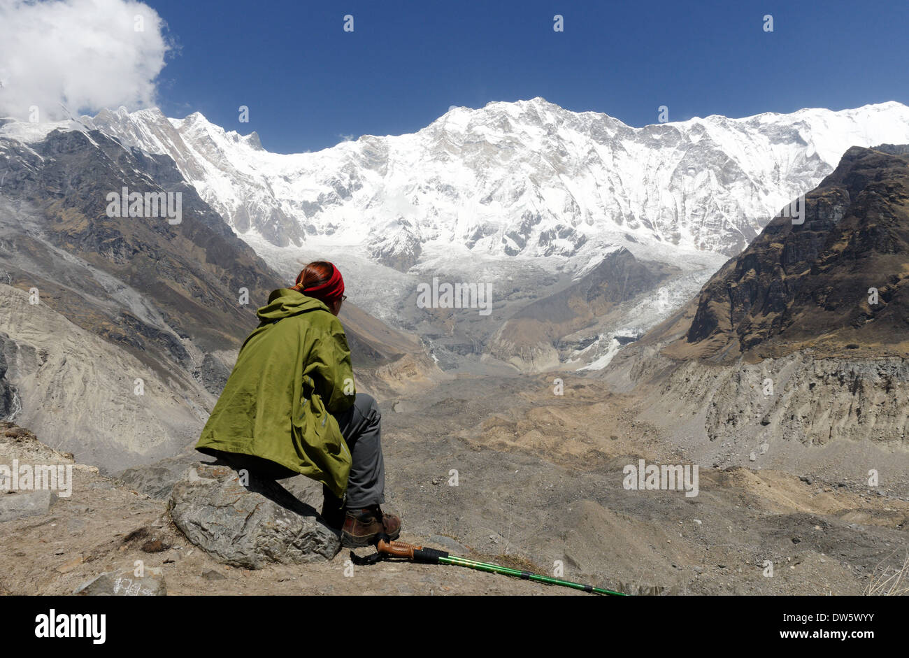 Eine Dame Trekker sitzt bewundern die riesige Landschaft im Annapurna Sanctuary, Nepal Stockfoto
