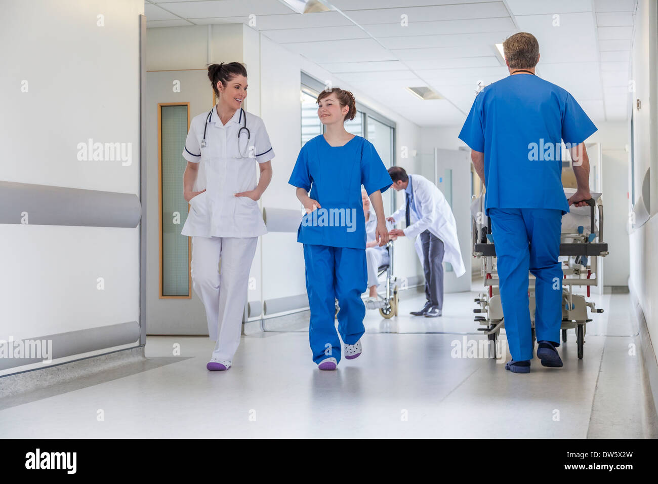 Krankenpfleger Krankenhausflur mit männlichen & weibliche Ärzte & Krankenschwestern & senior Patientin Stretcher Gurney Bett einschieben Stockfoto