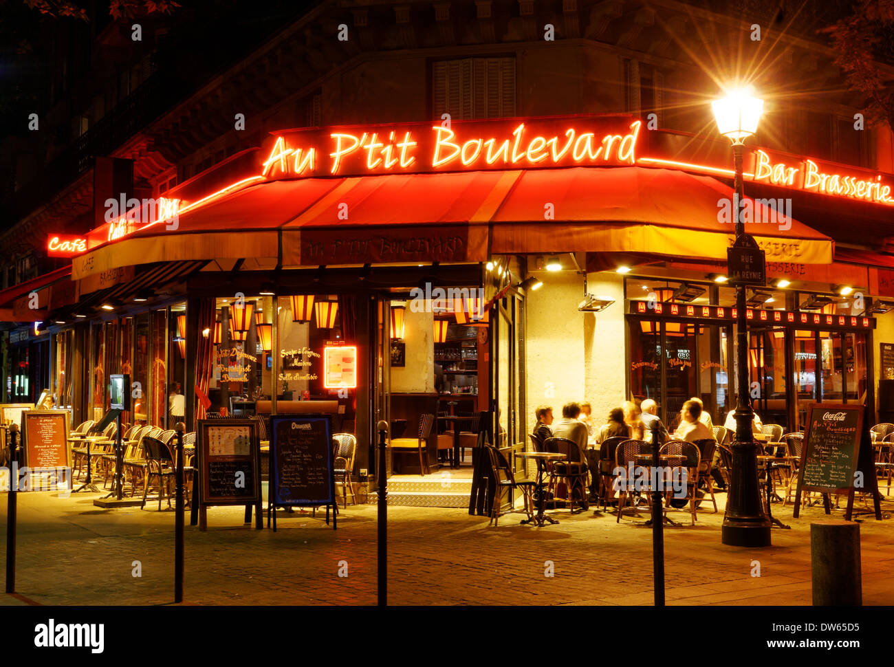 Ein hell erleuchteter Café in Paris bei Nacht Stockfoto