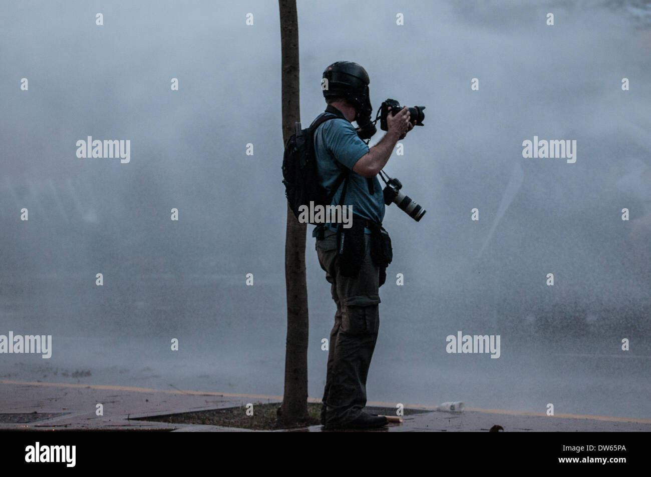 Altamira, Venezuela. 28. Februar 2014. Eine Fotojournalist arbeitet während einer Protestaktion in Altamira, im Gemeindegebiet von Chacao, östlich von Caracas, Venezuela, am 28. Februar 2014. Der venezolanische Präsident Nicolas Maduro eröffnet eine andere Sitzung der nationalen Konferenz für Frieden am Freitag, will das Land wochenlangen gewalttätigen Protesten ein Ende gesetzt. Bildnachweis: Boris Vergara/Xinhua/Alamy Live-Nachrichten Stockfoto