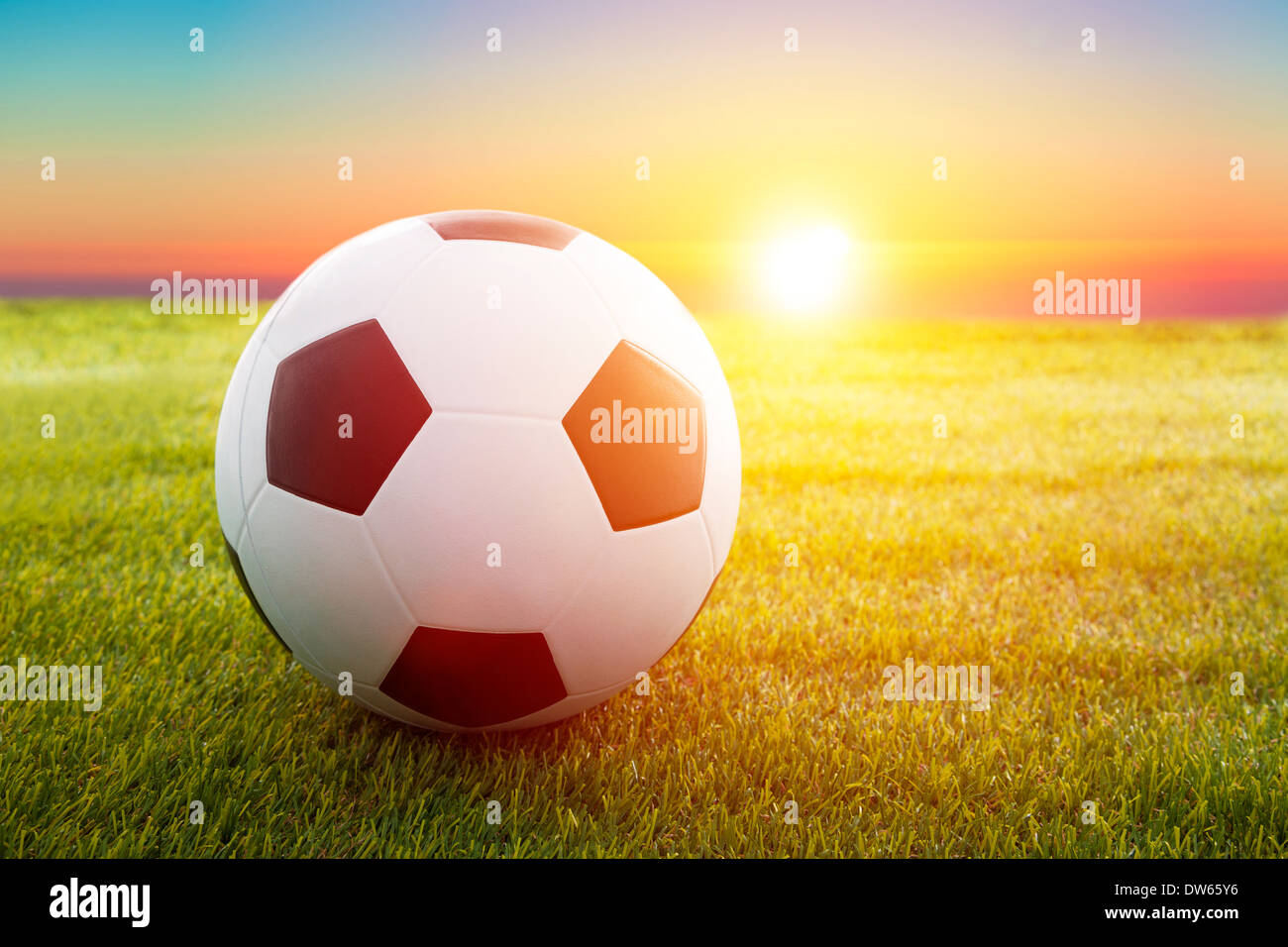 Fußball- oder Fußball Ball an dem Anpfiff eines Spiels mit Sonnenuntergang auf einer Wiese Stockfoto
