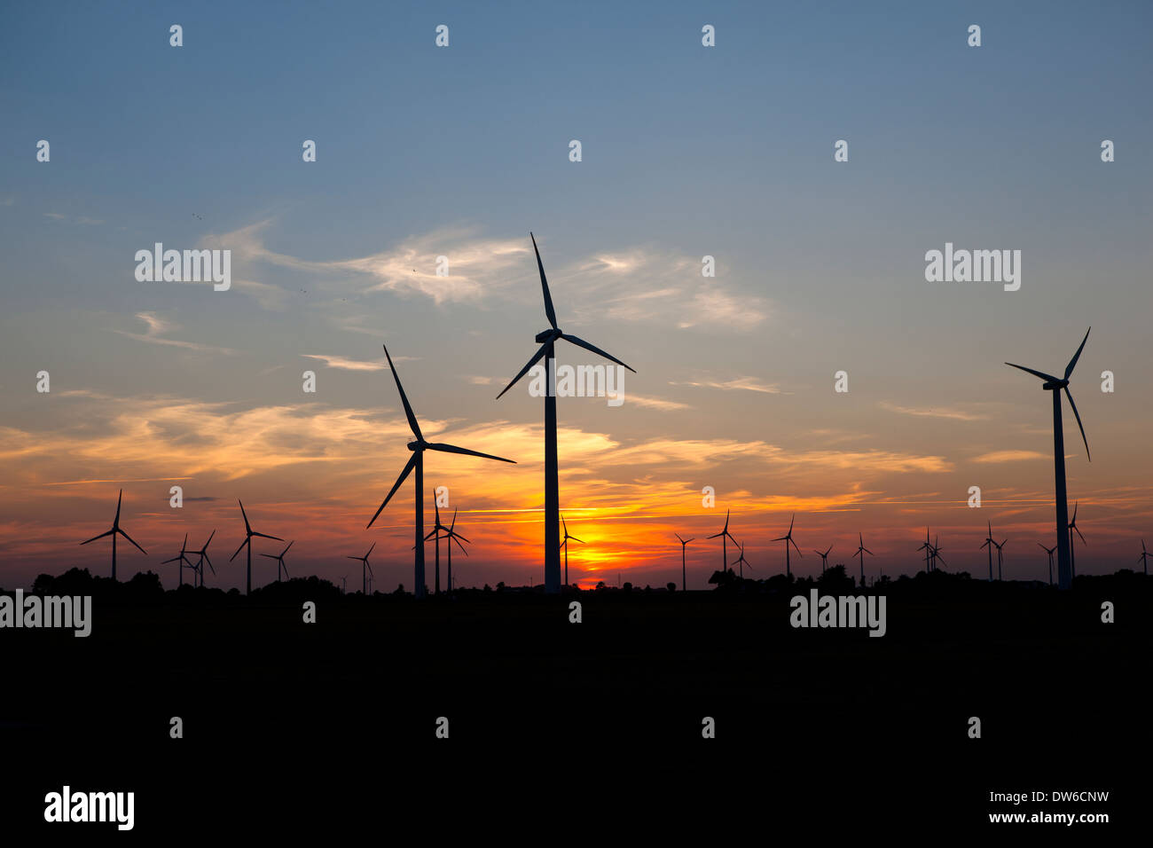 Windmühlen zur Stromerzeugung im Abendlicht. im Hintergrund der untergehenden Sonne Stockfoto