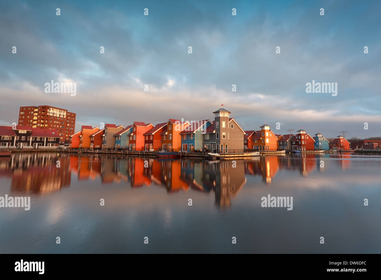 bunte Gebäude auf dem Wasser im morgendlichen Sonnenlicht, Groningen, Niederlande Stockfoto