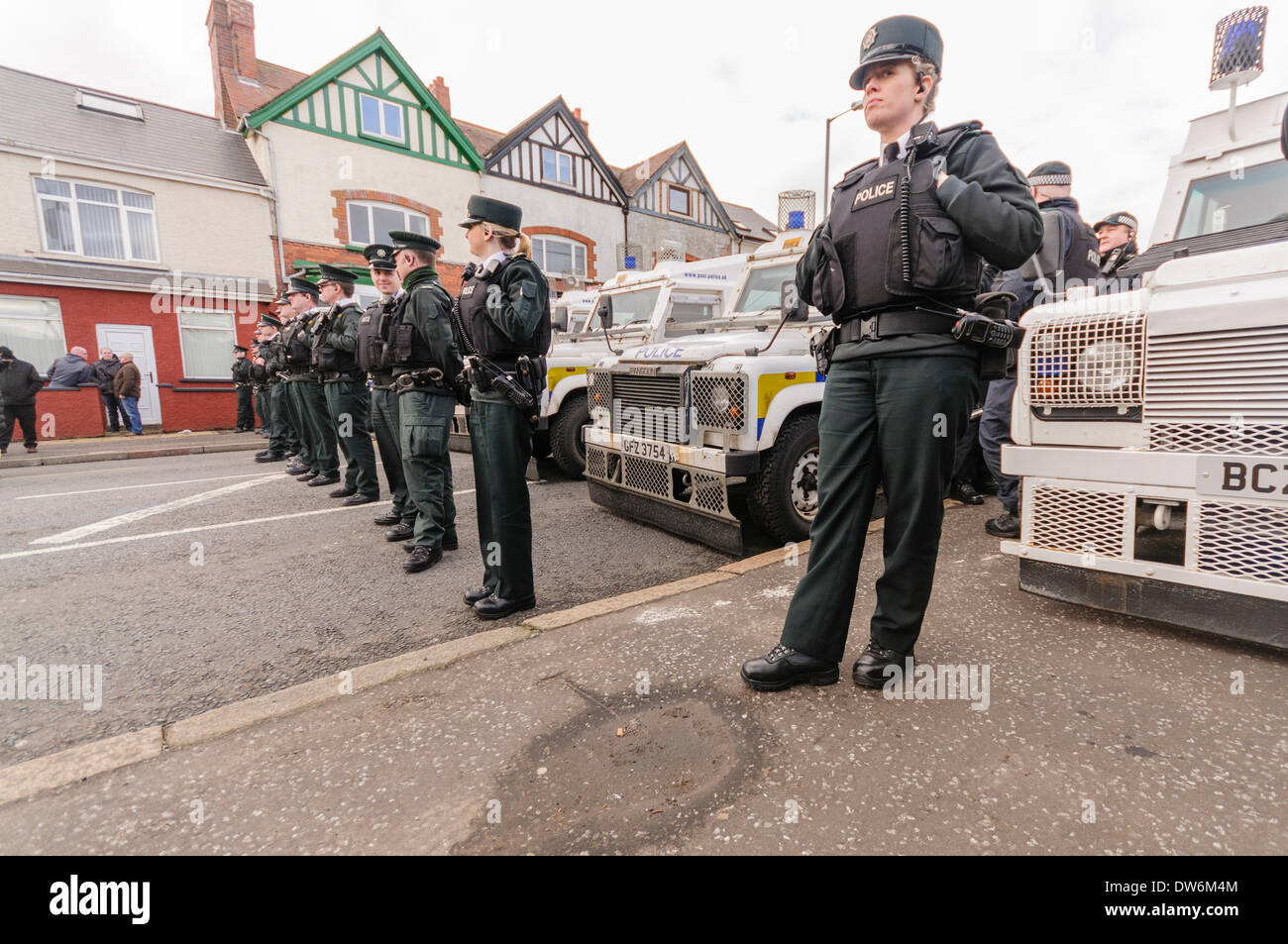 Polizisten aus der PSNI Line-up vor gepanzerten Landrover, auf die Straße zu blockieren. Stockfoto