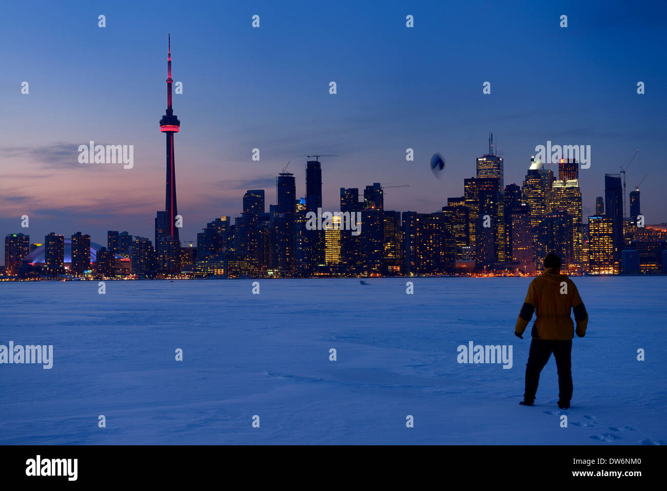 Man beobachtete Snowkite Skifahrer am zugefrorenen See Ontario in der Abenddämmerung mit Toronto Skyline der Stadt im winter Stockfoto