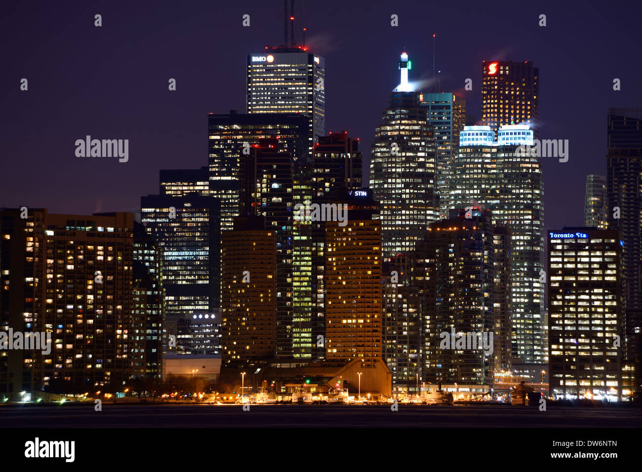 Lichter von Toronto Innenstadt Eigentumswohnung und Bank Towers bei Nacht im Winter von gefrorenen Schnee bedeckt Lake Ontario Stockfoto