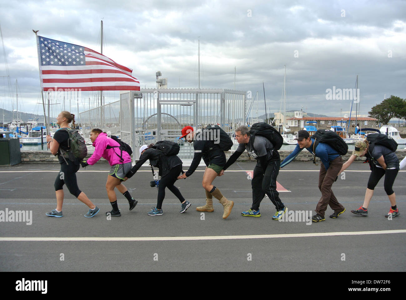 San Francisco, USA. 1. März 2014. Frauen Handlungsinstrumente amerikanische Flagge führt Team der Auszubildenden in das Goruck leichte Herausforderung, eine anstrengende körperliche Team Para militärische wie 10-Meilen Marsch im Marina District von San Francisco auf Samstag, 1. März 2014 Credit: Bob Kreisel/Alamy Live News Stockfoto