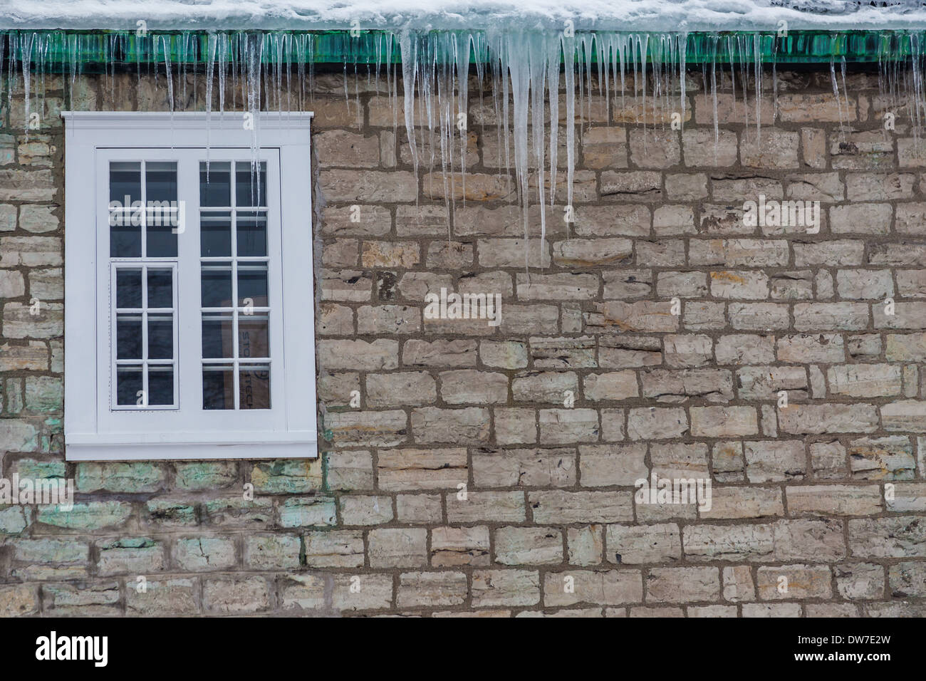Abstraktes Bild von Eiszapfen gegen eine Mauer in der Altstadt von Quebec City, Kanada Stockfoto
