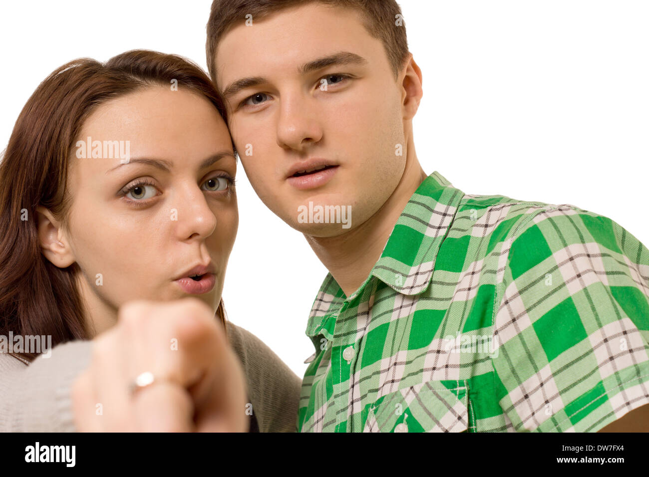 Junges Paar zeigt auf die Kamera mit ihren Köpfen nahe beieinander liegen, Detailansicht mit Fokus auf ihren Gesichtern, isoliert auf weiss. Stockfoto