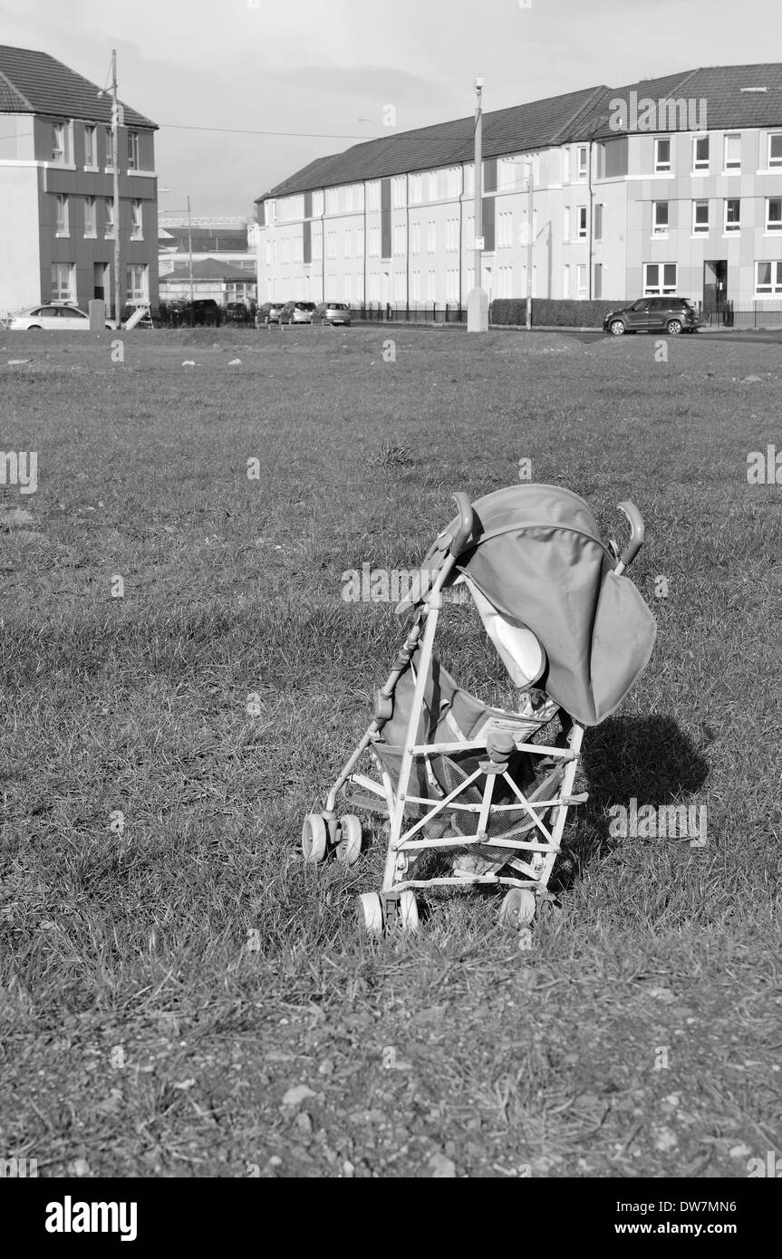 Gebrochen am Boden liegen verlassene Kinderwagen gelöscht von Häusern im East End von Glasgow Stockfoto