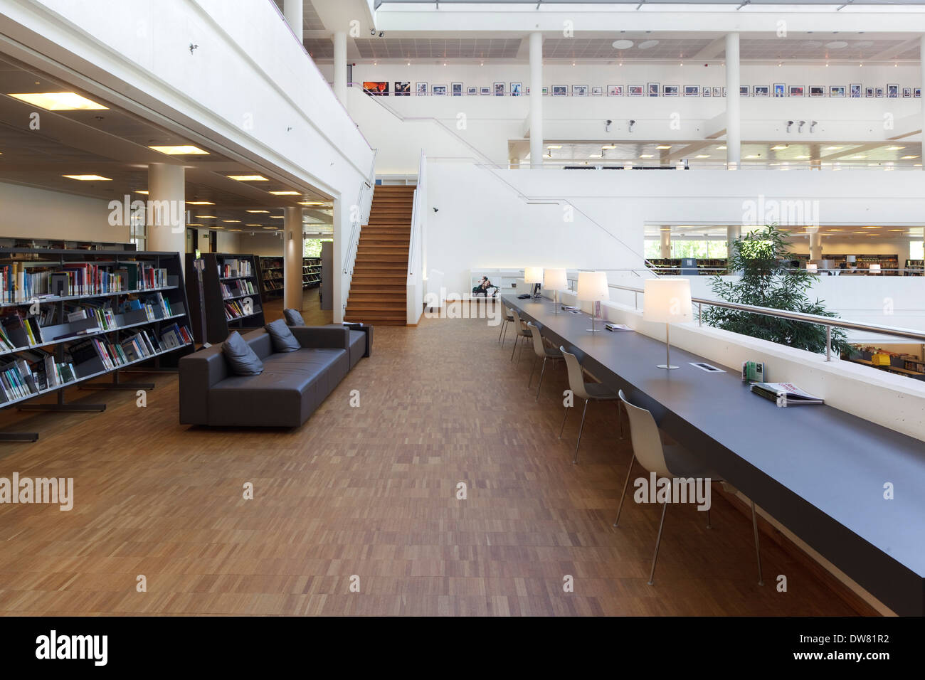 Genk Public Library, Genk, Belgien. Architekt: Claude Vasconi, 2008. Ersten Stock mit Braune Ledercouch, Bücherregale und Schreibtisch, ein Stockfoto