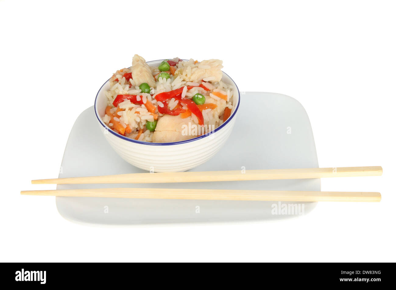 Schüssel mit Chines Huhn und Gemüse Reis mit Stäbchen auf dem Teller isoliert gegen weiß Stockfoto