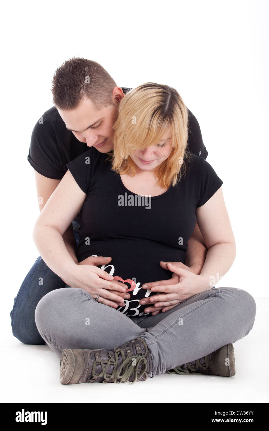 Glückliche junge schwangere paar im studio Stockfoto