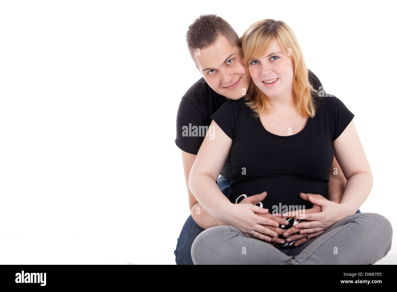 Glückliche junge schwangere paar im studio Stockfoto