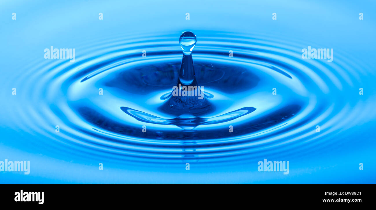 Wassertropfen nach schlagen und erholt Sie Wasser mit einem blauen Hintergrund. Stockfoto