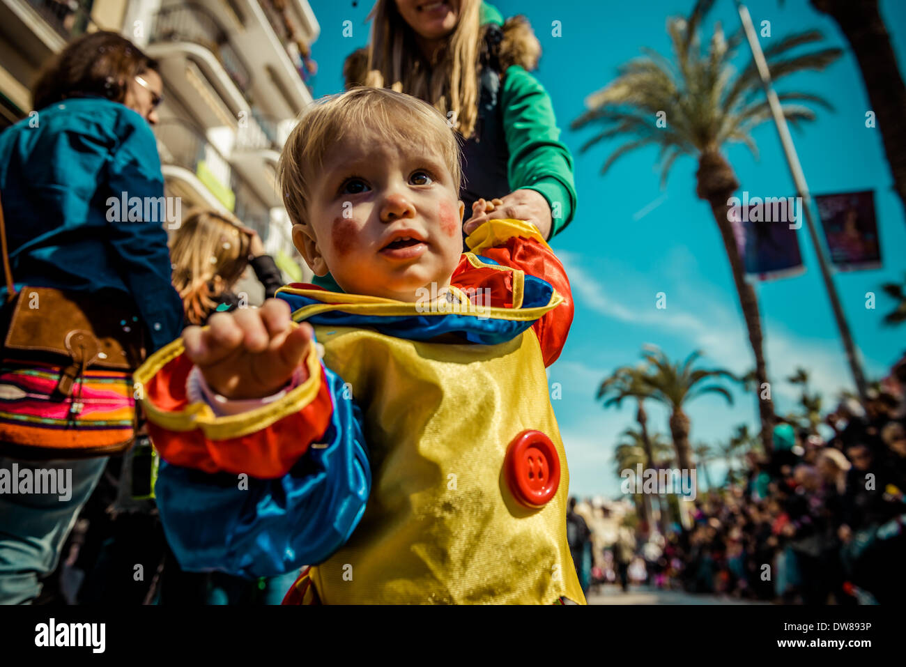 Sitges, Spanien. 2. März 2014: Ein kleiner Junge in einem Clownskostüm zeigt sein Interesse an der Fotografie und unterstützen die Kinder-Karnevalsumzug in Sitges Credit: Matthi/Alamy Live-Nachrichten Stockfoto