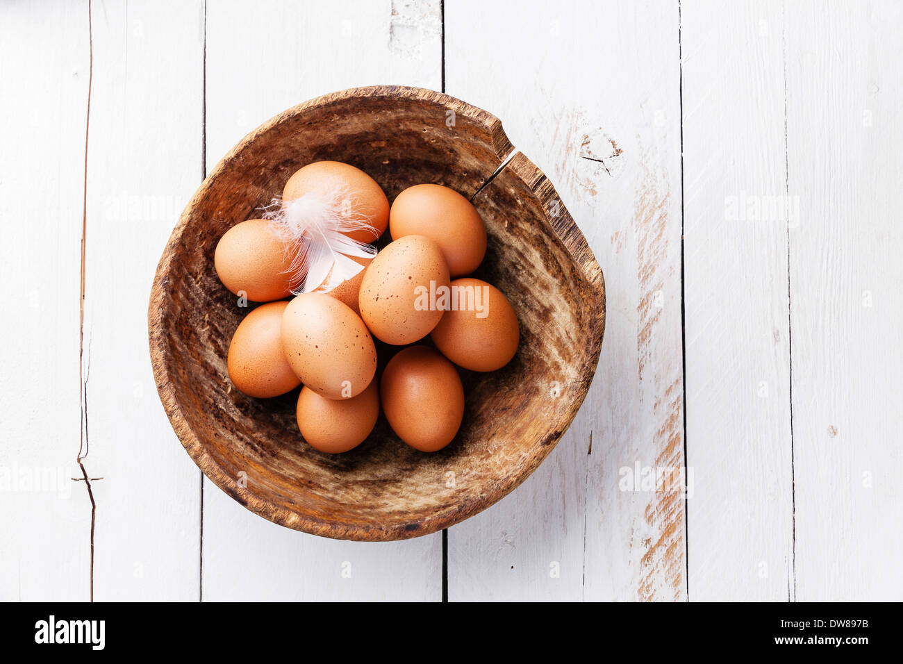 Eiern in Schüssel auf hölzernen Hintergrund Stockfoto