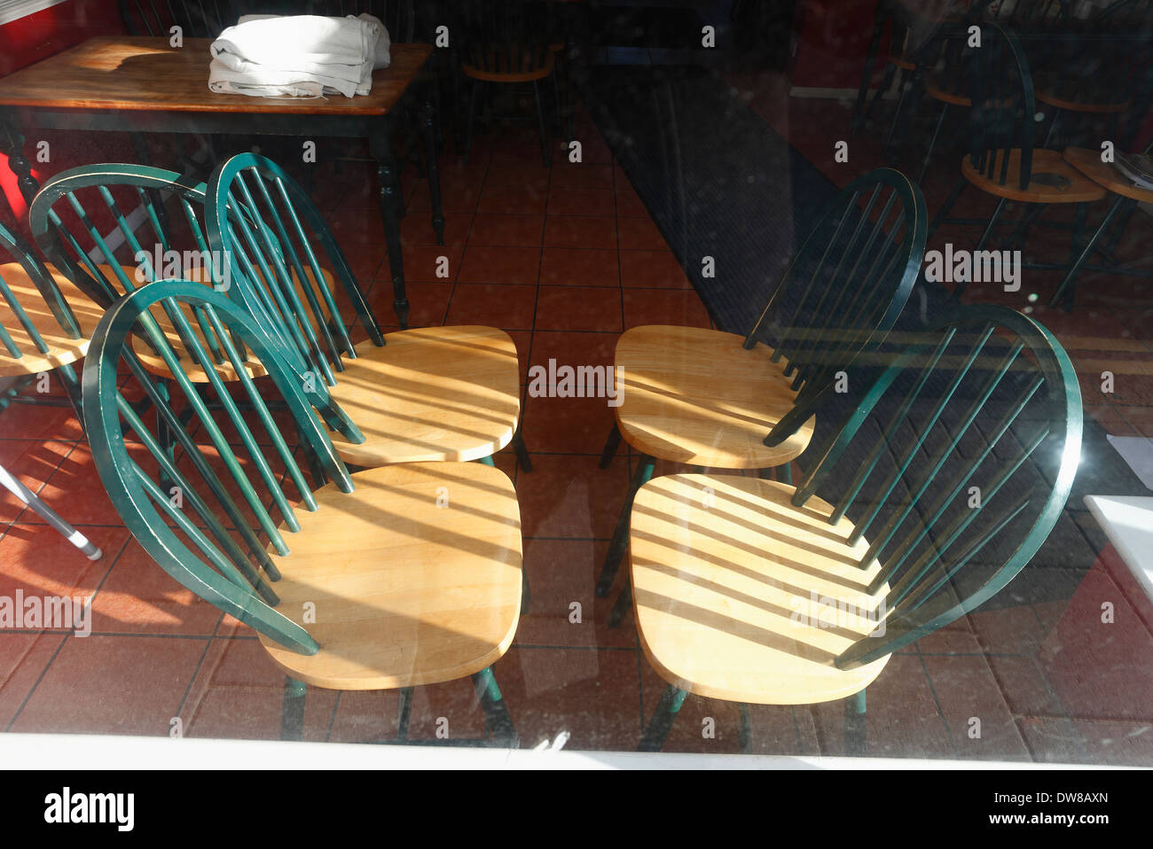 Leere Stühle in das Fenster eines geschlossenen Cafés auf Sheringham High Street, Norfolk, England gesehen. Stockfoto