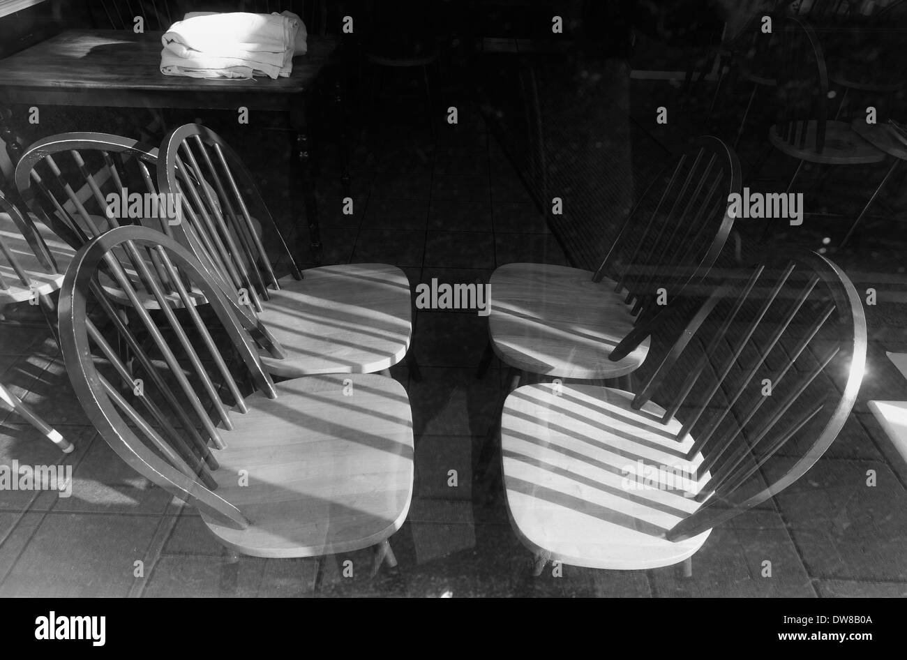 Leere Stühle in das Fenster eines geschlossenen Cafés auf Sheringham High Street, Norfolk, England gesehen. Stockfoto