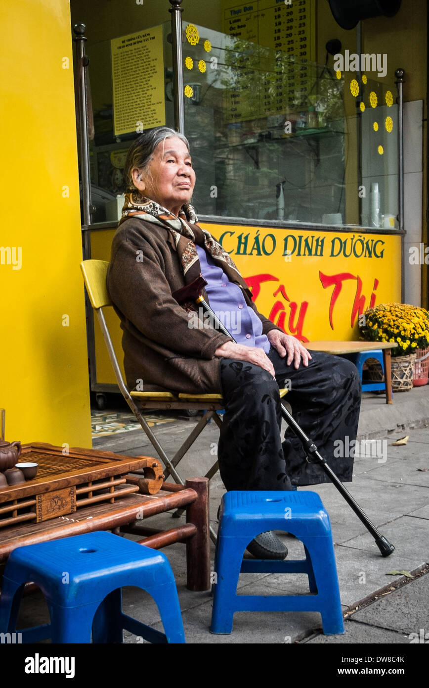 HANOI, VIETNAM - 27.Januar: eine ältere vietnamesische Frau sitzt auf der Straße in der Länder-Hauptstadt Hanoi im Januar 201 Stockfoto